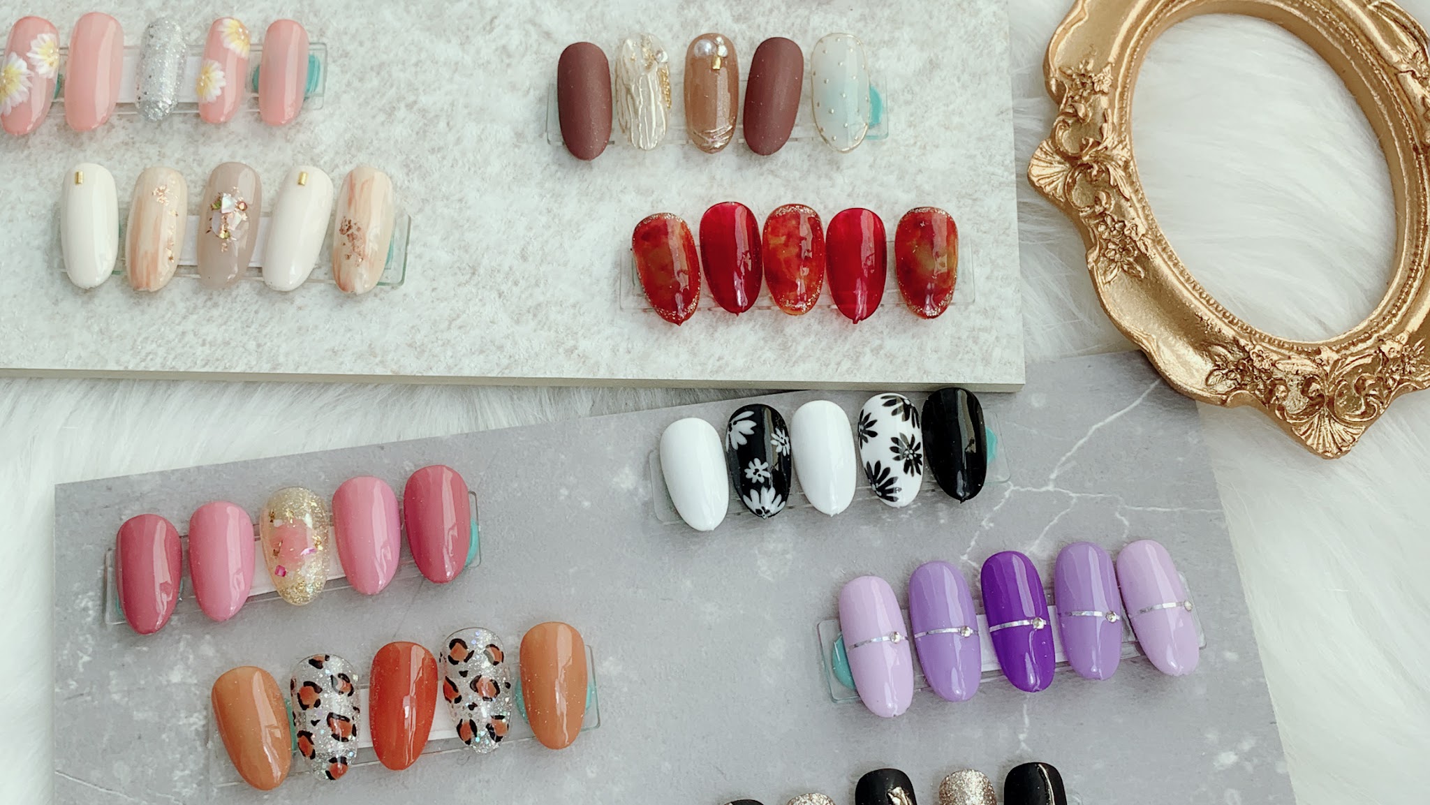 Voorbeeldtips op twee rekjes: roze, rood, zwart-wit, luipaard en lila designs naast een gouden spiegellijst