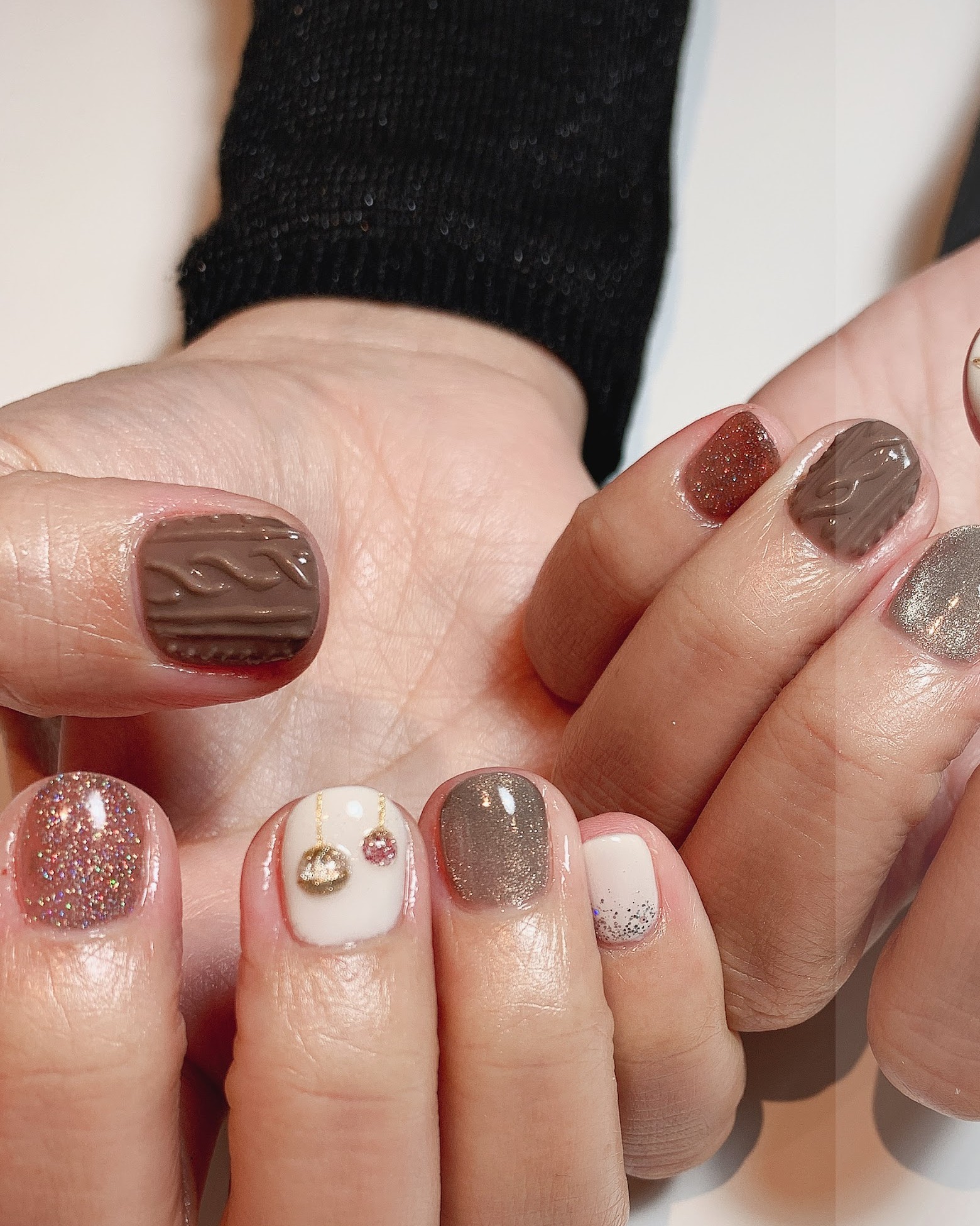 Gelnagels in bruin en taupe met glitter en kleine bedels