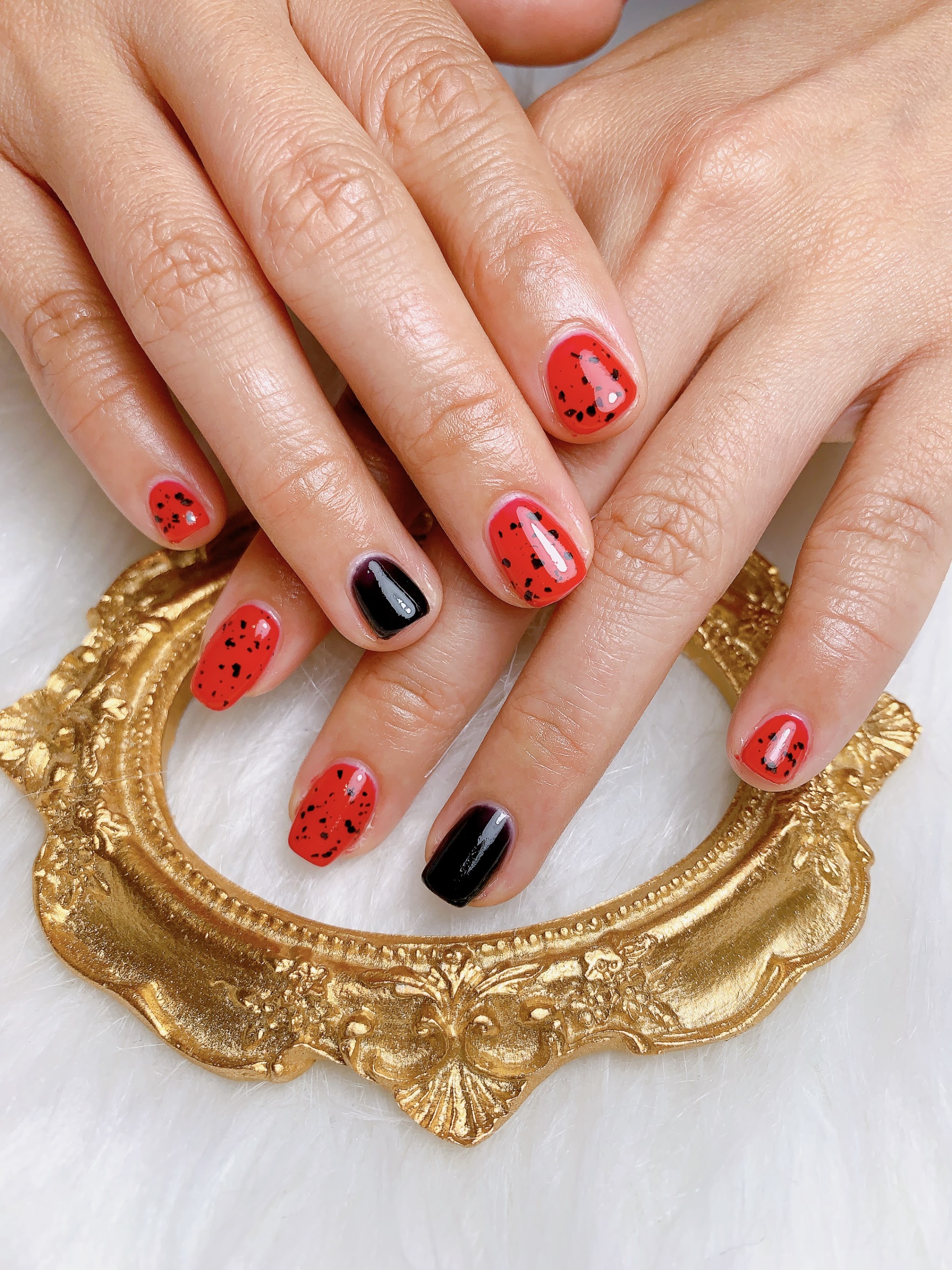Rode en zwarte watermeloen nail art, handen op een gouden spiegellijst